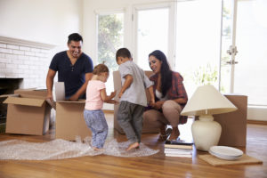 Parents and two young children unpacking boxes together in their new home